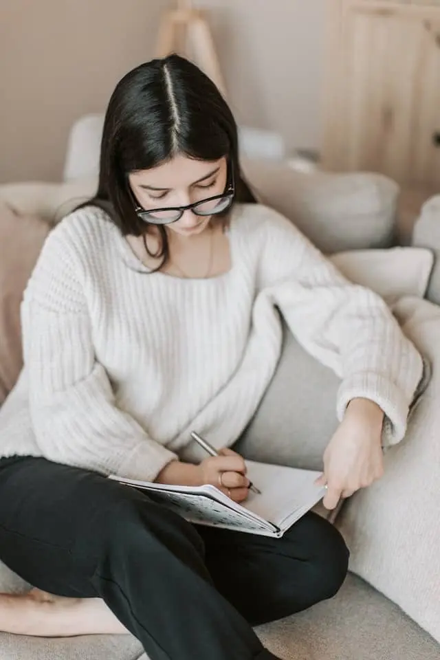 Femme écrivant dans un journal intime pour exprimer ses pensées et cultiver son bien-être