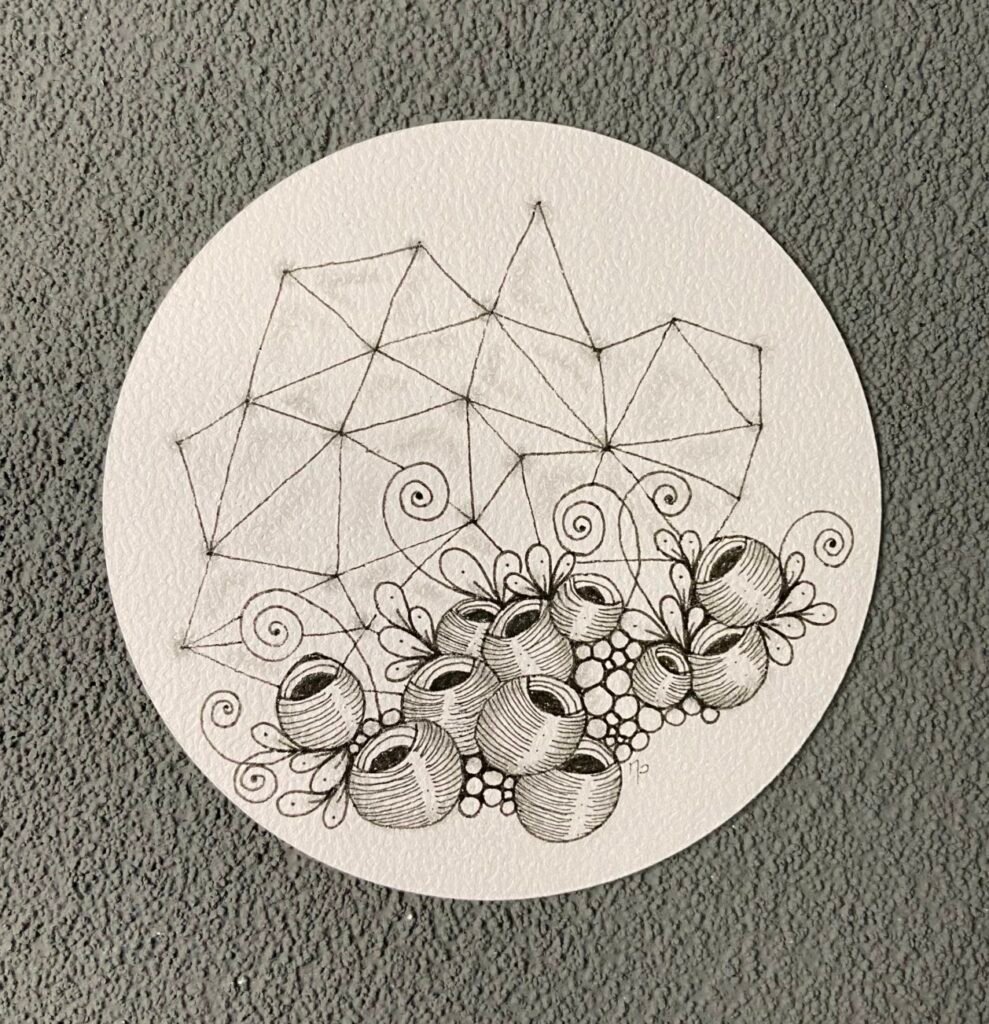 uile ronde Zentangle avec motifs géométriques et perles en noir et blanc.
